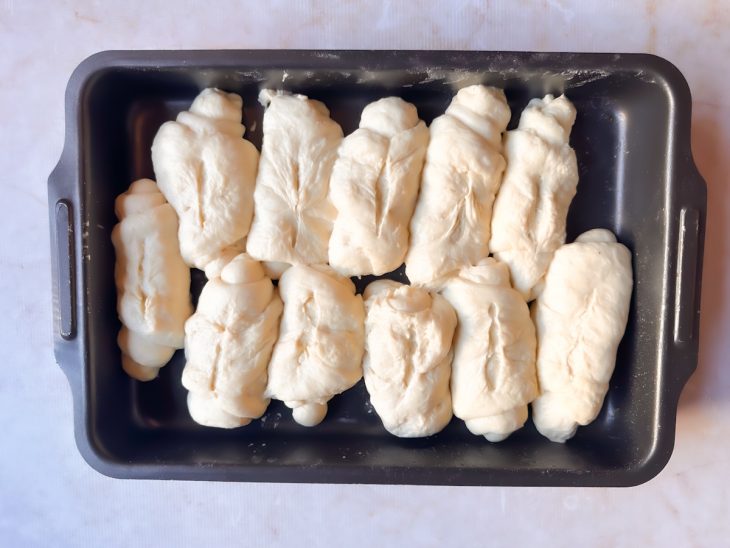 Pães com cortes centrais na assadeira.