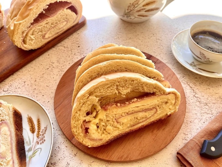 Uma bancada com fatias de pão caseiro recheado.