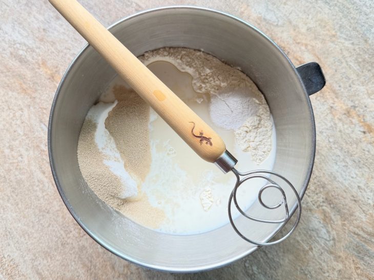 Na tigela, a farinha de trigo, o sal, açúcar, fermento, os ovos, o leite morno e o mingau.