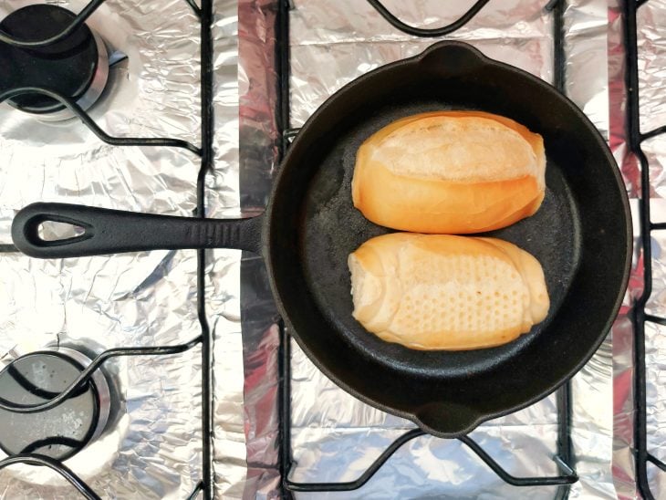 Pães em uma frigideira com o recheio virado para baixo.