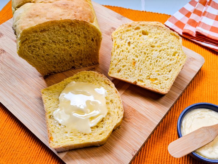 Pão de abóbora fatiado com requeijão.