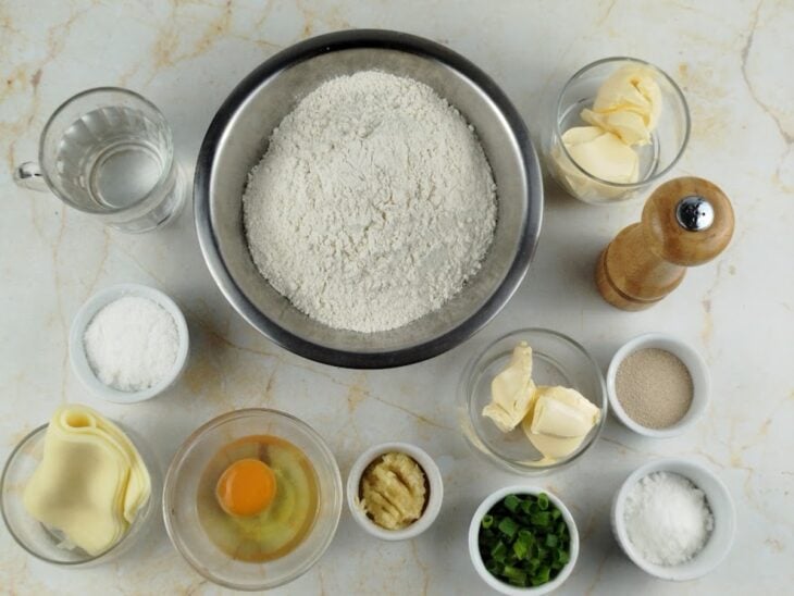 Ingredientes da massa e da cobertura organizados na bancada com um ovo batido em uma tigela.