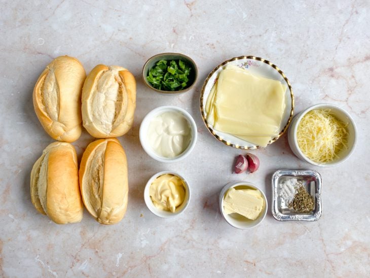 Ingredientes para a receita de pão de alho fácil e rápido reunidos em uma bancada.
