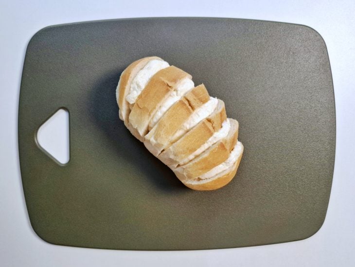 Creme de alho adicionado entre os cortes que foram feitos no pão.