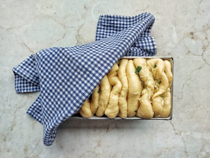 Forma com o pão semi coberta com pano.