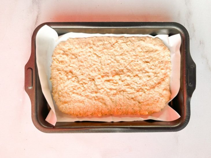 Massa despejada na forma com papel manteiga.