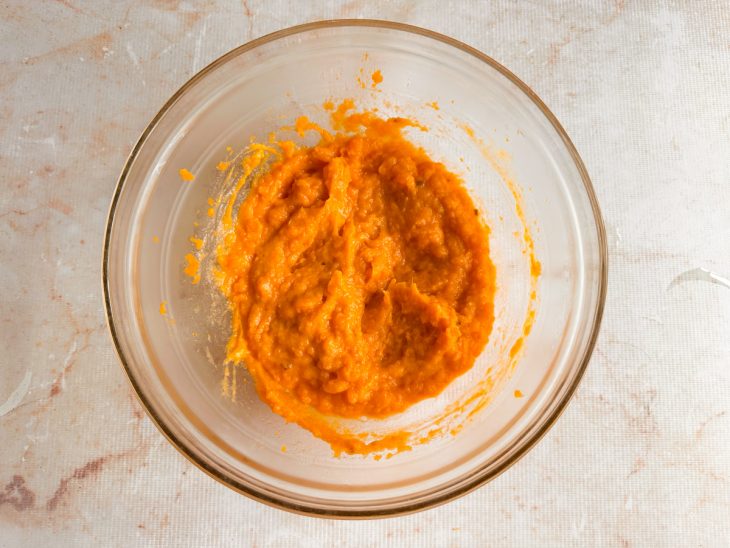 Batata-doce misturada com óleo e ovo formando uma massa cremosa.