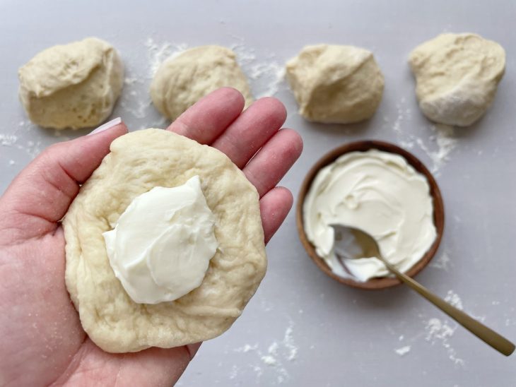 Porções de massa abertas e recheadas com catupiry.