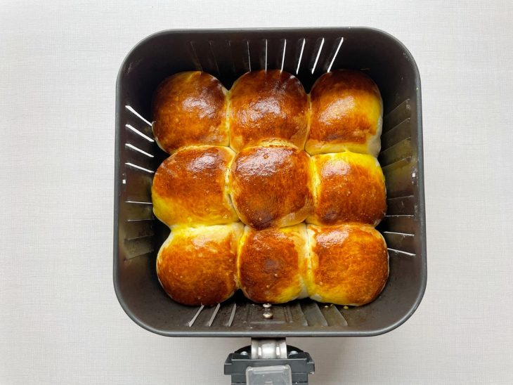 Pães assados e dourados, com recheio cremoso por dentro.