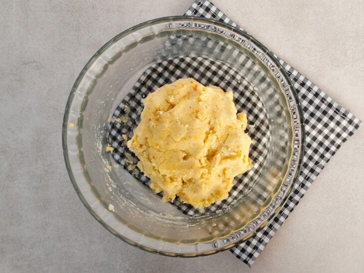 Purê de batata sendo misturado com sal, azeite, levedura nutricional e farinha de linhaça.