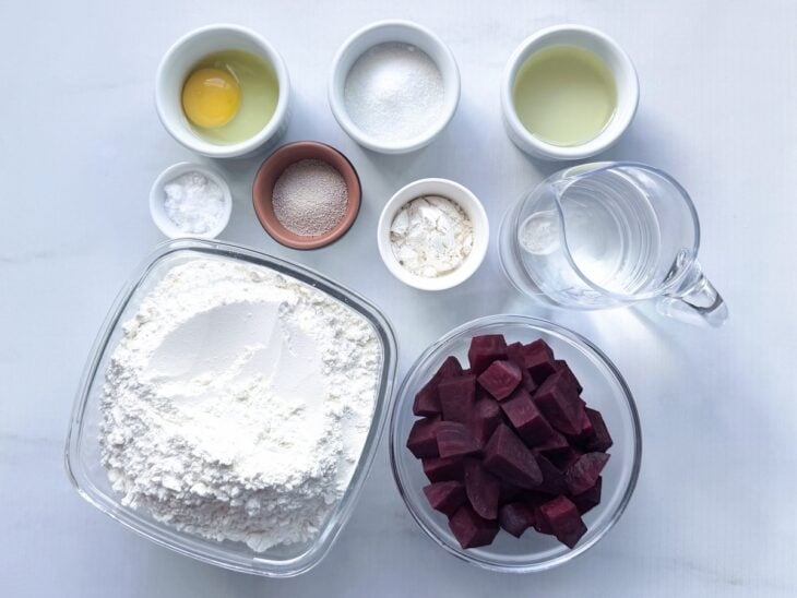 Ingredientes organizados sobre a bancada e beterraba sendo descascada e cortada em pedaços.