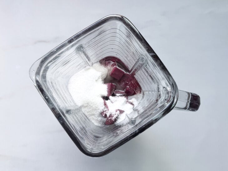 Mistura líquida sendo coada para remover fibras mais grossas da beterraba.