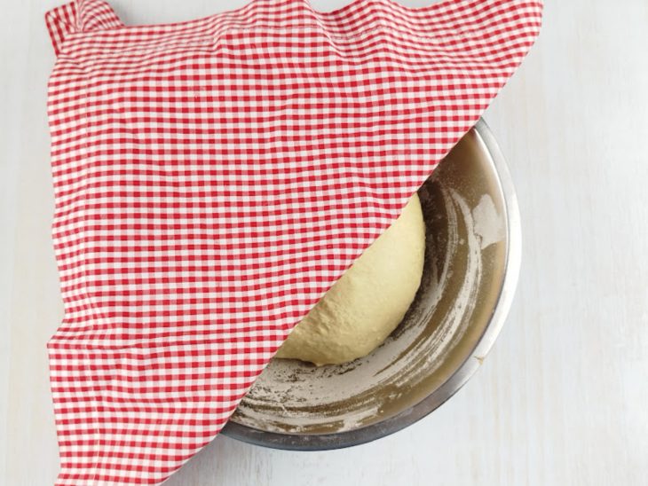 Massa descansando em um recipiente coberto.