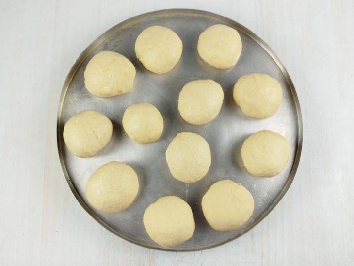 Massa de pão dividida e posicionada na assadeira.