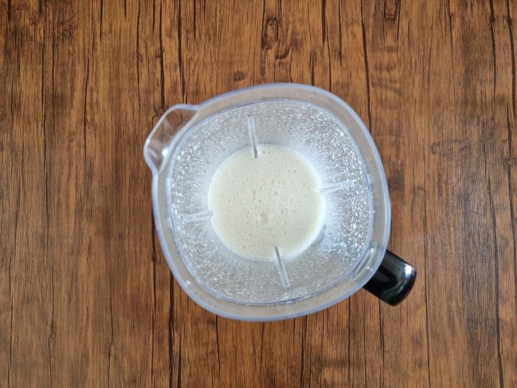 Um liquidificador com uma mistura de leite, o ovo, o fermento, o azeite, o açúcar e o sal.