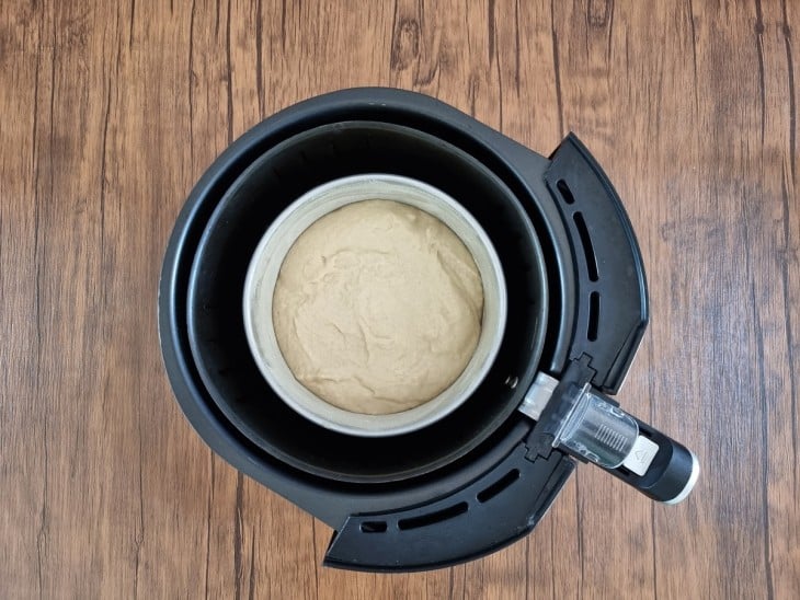 A cesta da airfryer com a forma com o pão cru.