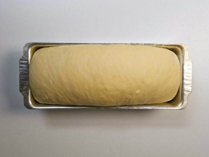 Massa acomodada na forma untada com a emenda para baixo.