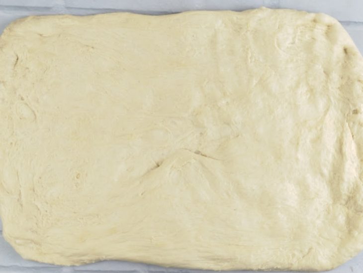 Na bancada, a massa sendo aberta.