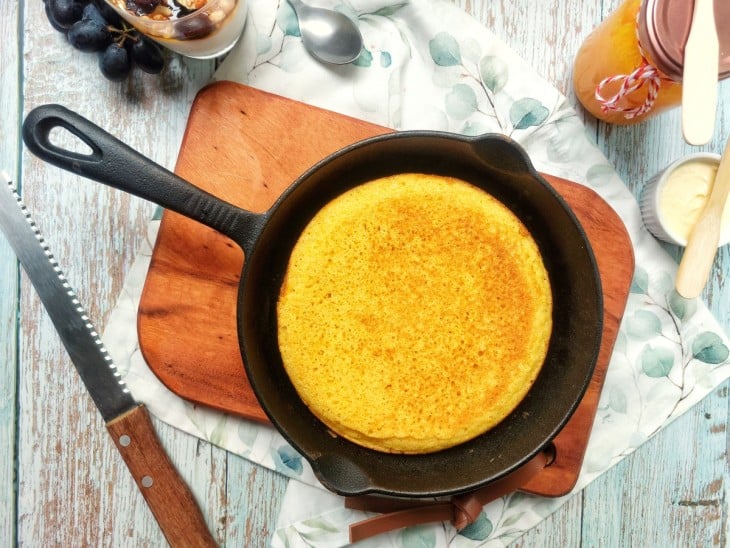 Uma bancada com a frigideira com o pão de fubá.