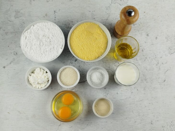 Ingredientes organizados sobre a bancada para o preparo do pão de fubá.