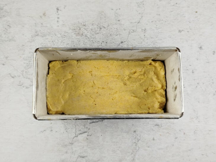 Forma untada recebendo a massa do pão.