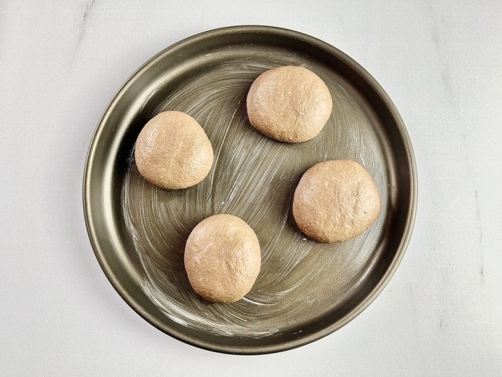 pão de hambúrguer em forma untada com manteiga.