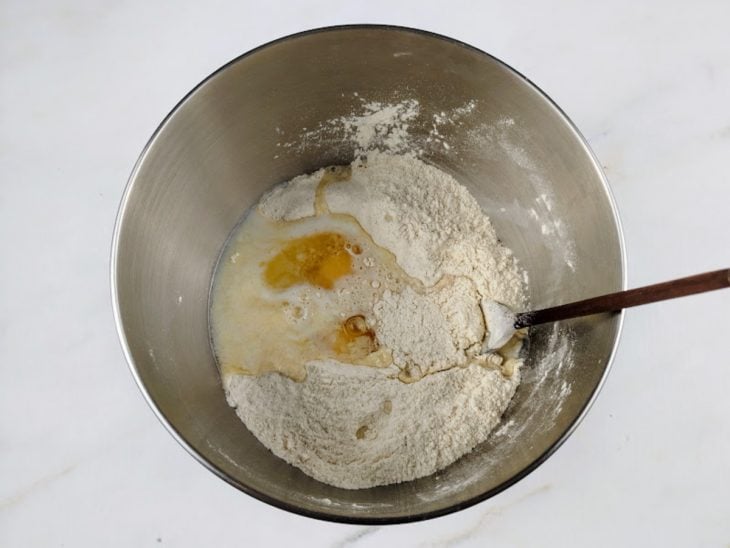 adição dos ovos a mistura seca da massa de pão.