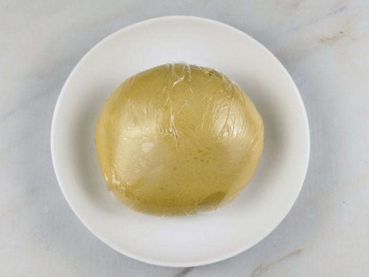 massa de pão brioche embalada em plástico filme para descansar em geladeira.