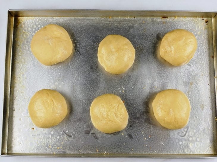 massas boleadas e assadeira untada com manteiga.