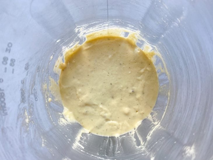 Um liquidificador contendo a mistura de leite, manteiga, ovos, açúcar, sal, queijo ralado, orégano, farinha e fermento.
