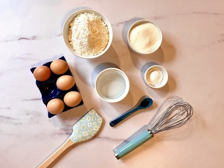 Uma bancada com os ingredientes separados do pão de ló.