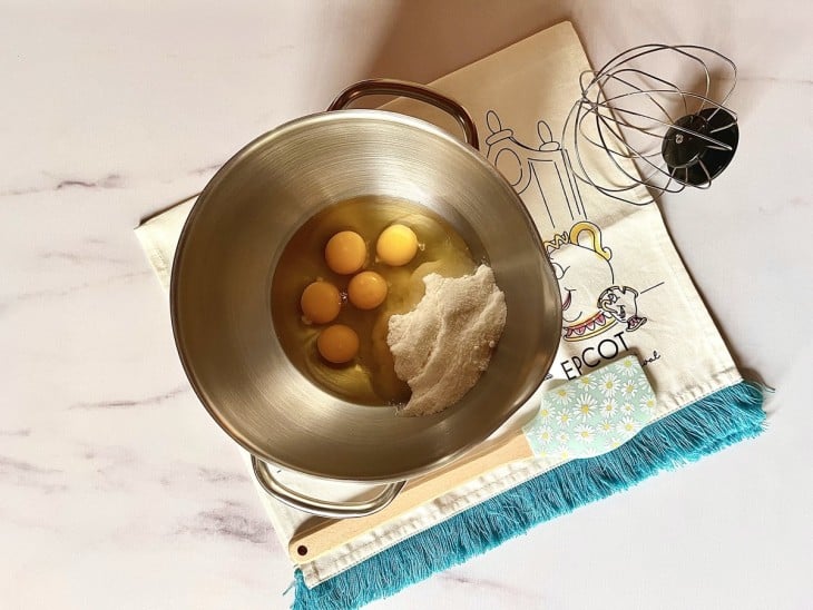 Um bowl de batedeira com ovos e açúcar.