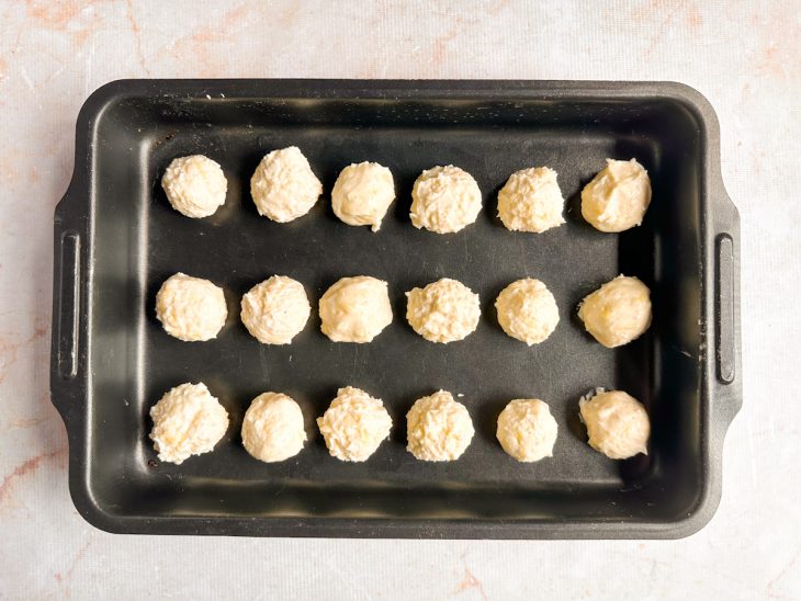 Bolinhas distribuídas numa assadeira retangular.