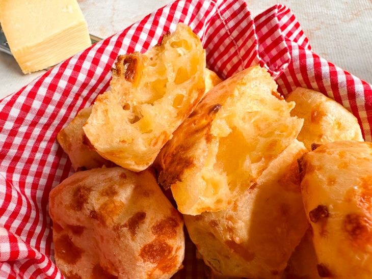 Pães de queijo com polvilho azedos prontos e cortados ao meio.