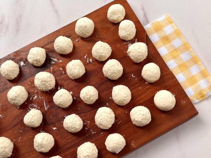 Uma tábua contendo as bolinhas cruas de pão de queijo.