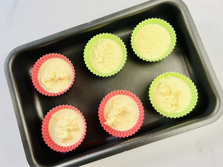 Massa de pão de queijo adicionada em forminhas de silicone.