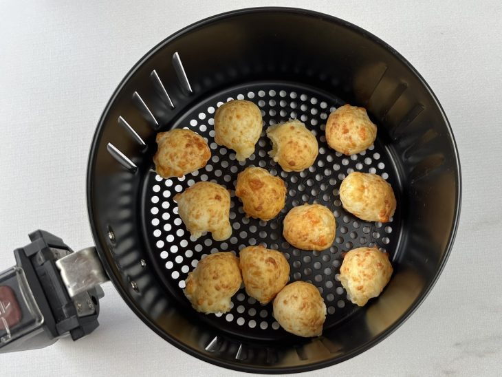 Pão de queijo de tapioca fritando na air fryer.