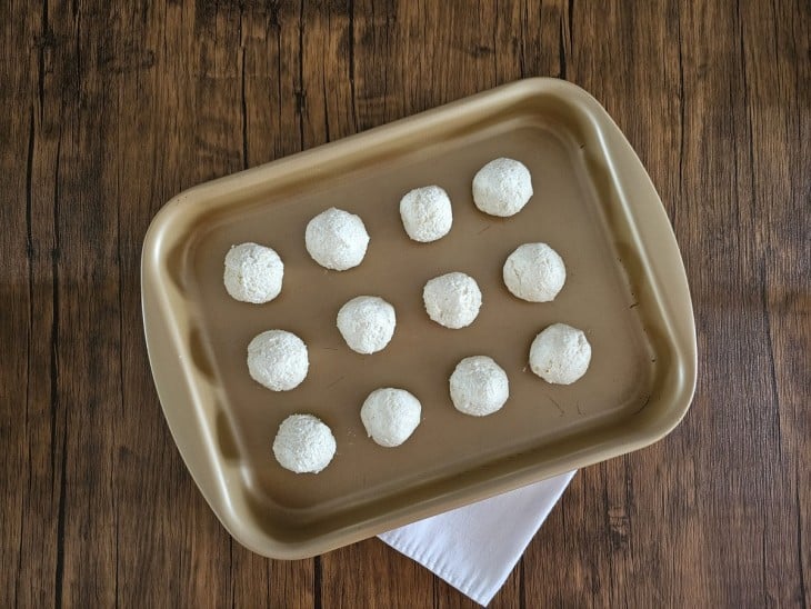 Uma forma com vários pães de queijo fit crus.