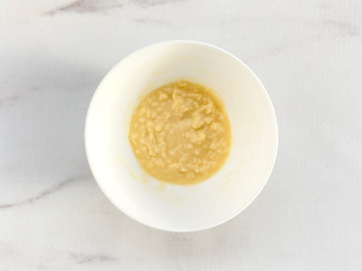 Um recipiente com ovo, queijo cottage, parmesão, mussarela e fermento.