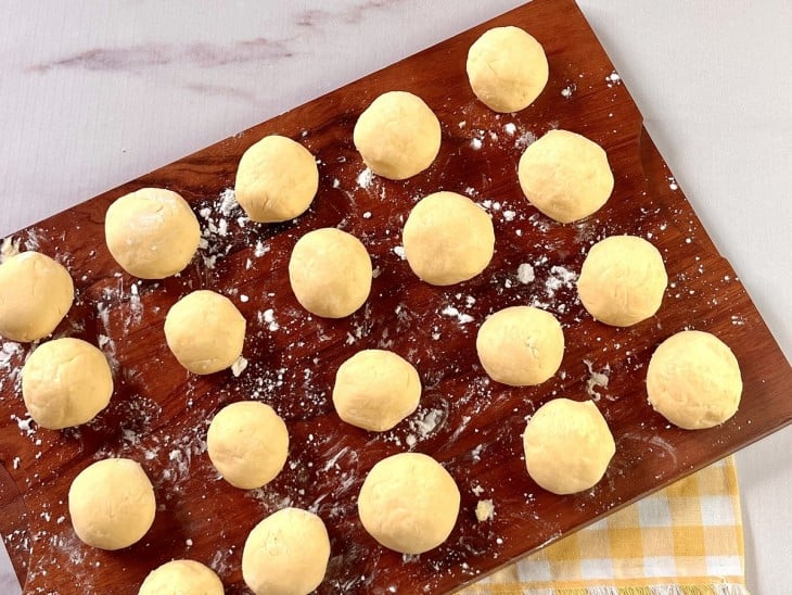 Bolinhas de pão de queijo em uma tábua.