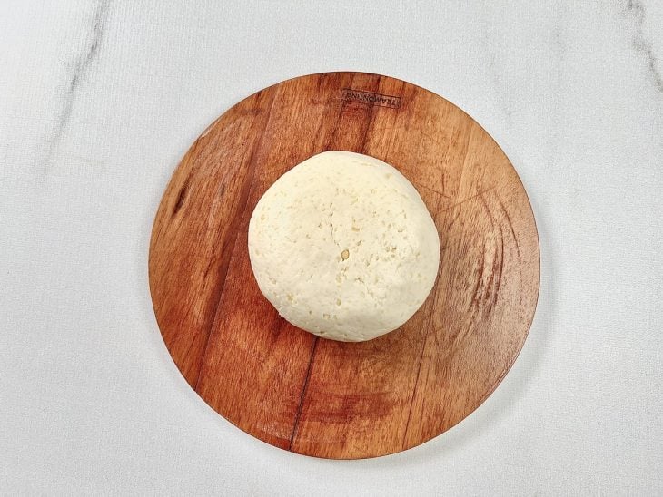 Massa do pão de queijo boleada em uma tábua.