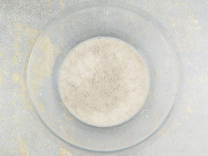 Mistura de leite morno com fermento e açúcar sendo mexida.