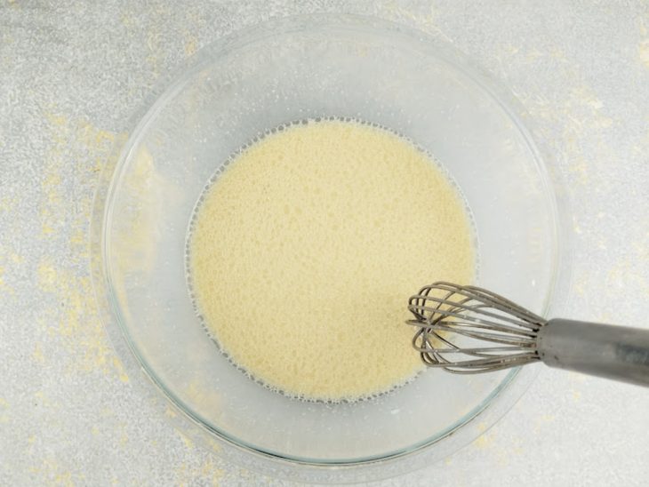 Adição de óleo e ovos batidos à mistura líquida.