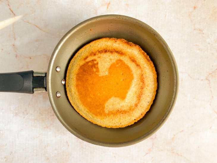 Um lado da massa dourado, virado para cozinhar do outro lado.