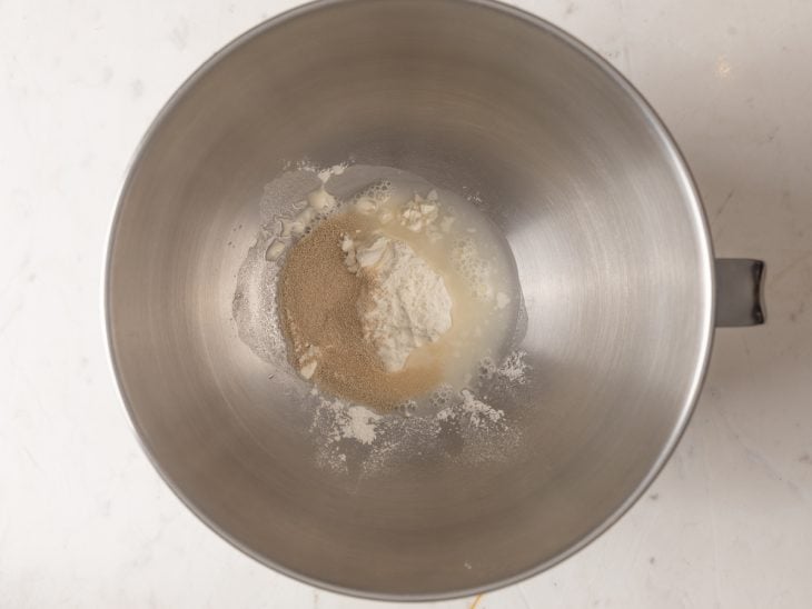 Farinha, fermento e água em uma tigela.