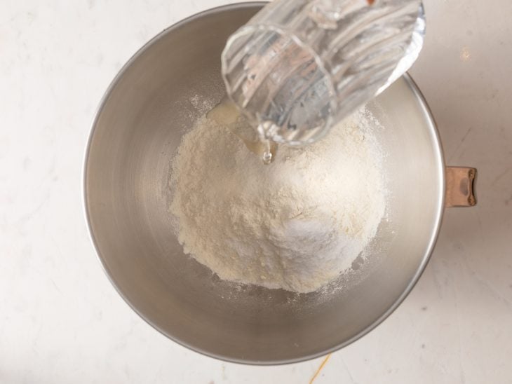 Água adicionada a tigela da batedeira com os demais ingredientes.