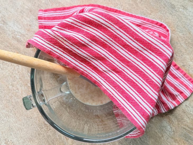 Açúcar, leite e fermento misturados em tigela semi coberta.