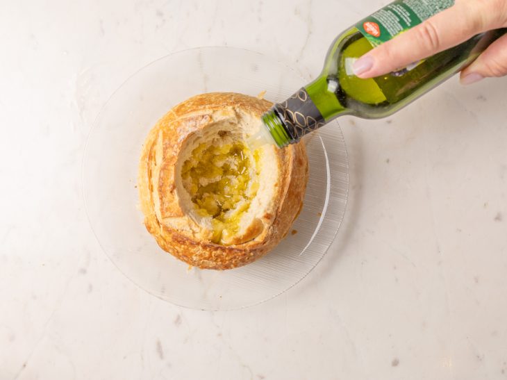 Pão sendo regado com azeite.