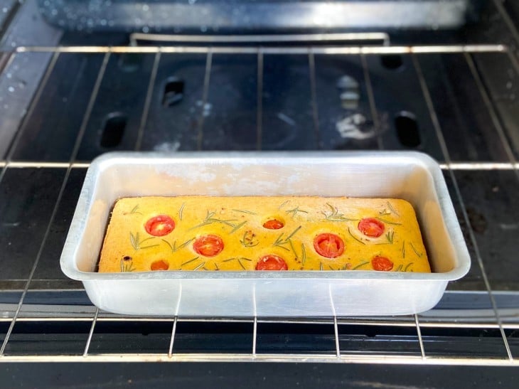 Um forno contendo uma forma com o pão cru.