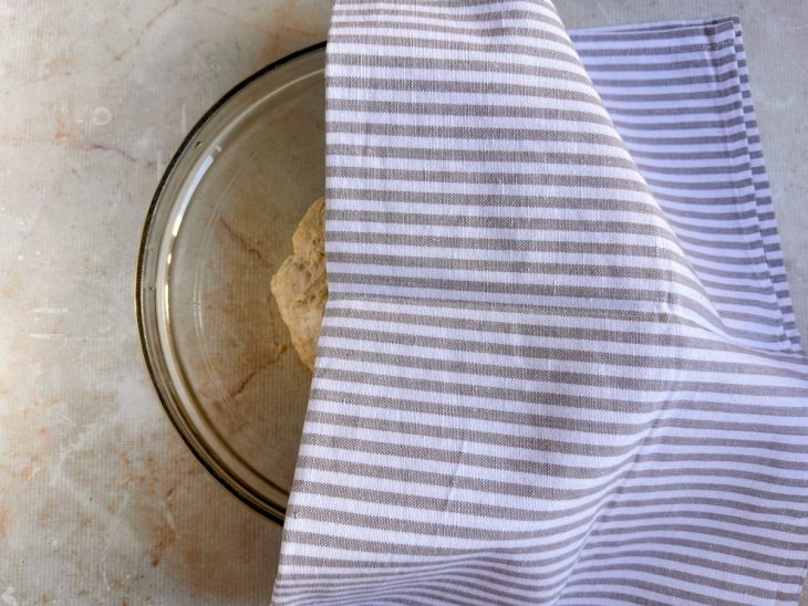 Massa na tigela, coberta com pano.